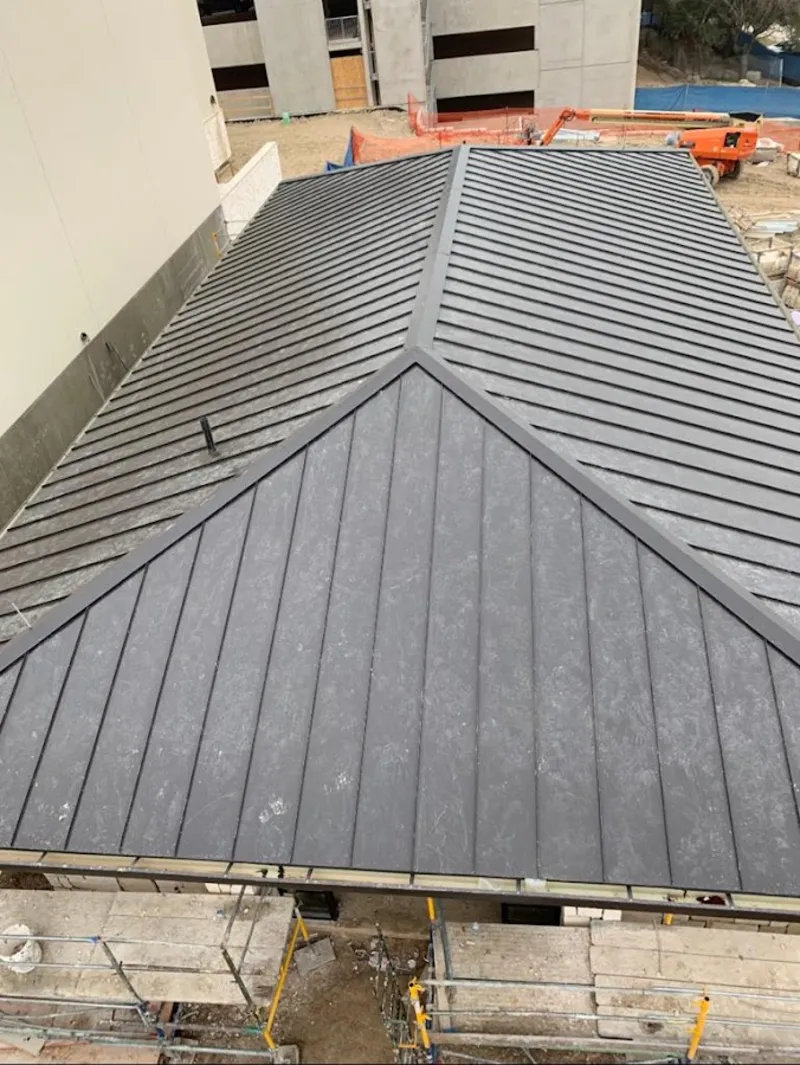 Commercial metal roof construction with crane equipment in Waukee